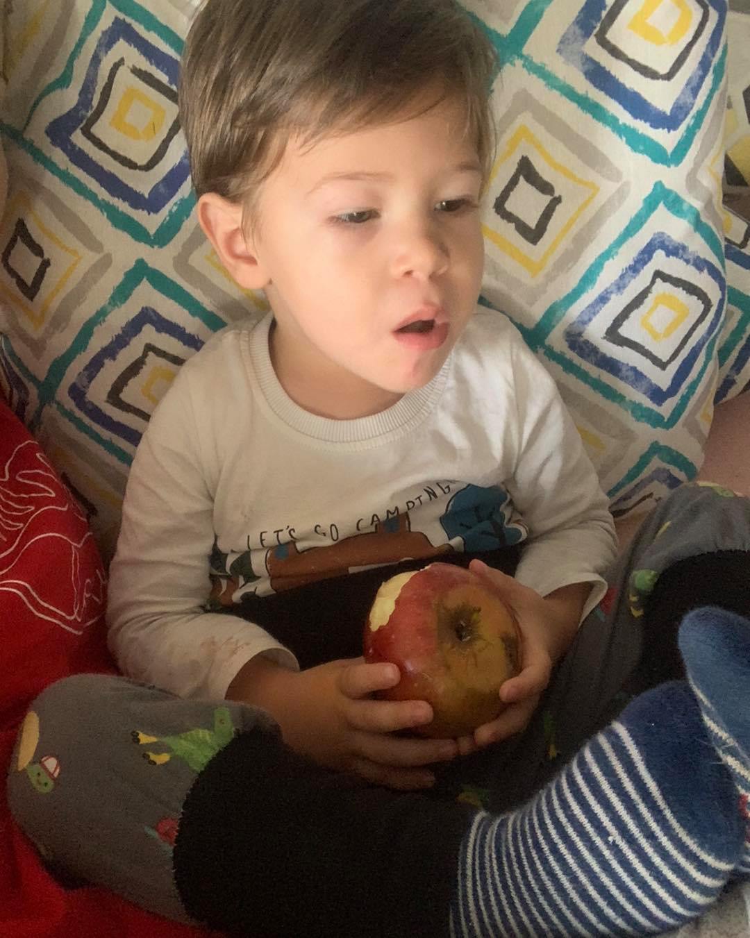 May be an image of child and apple